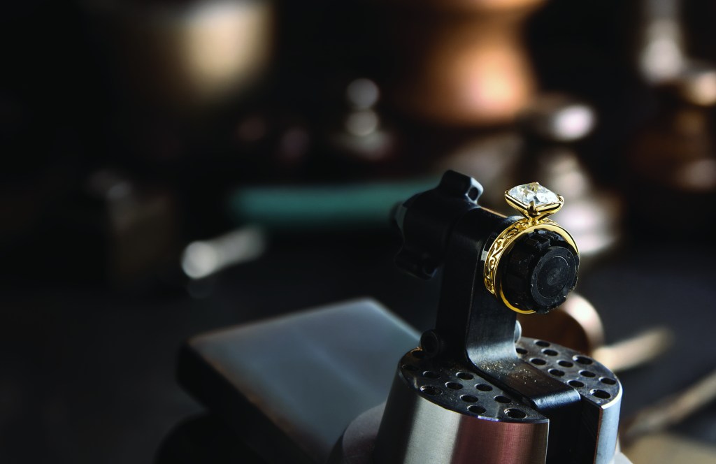 A jeweler resizing a ring held in a bench vice